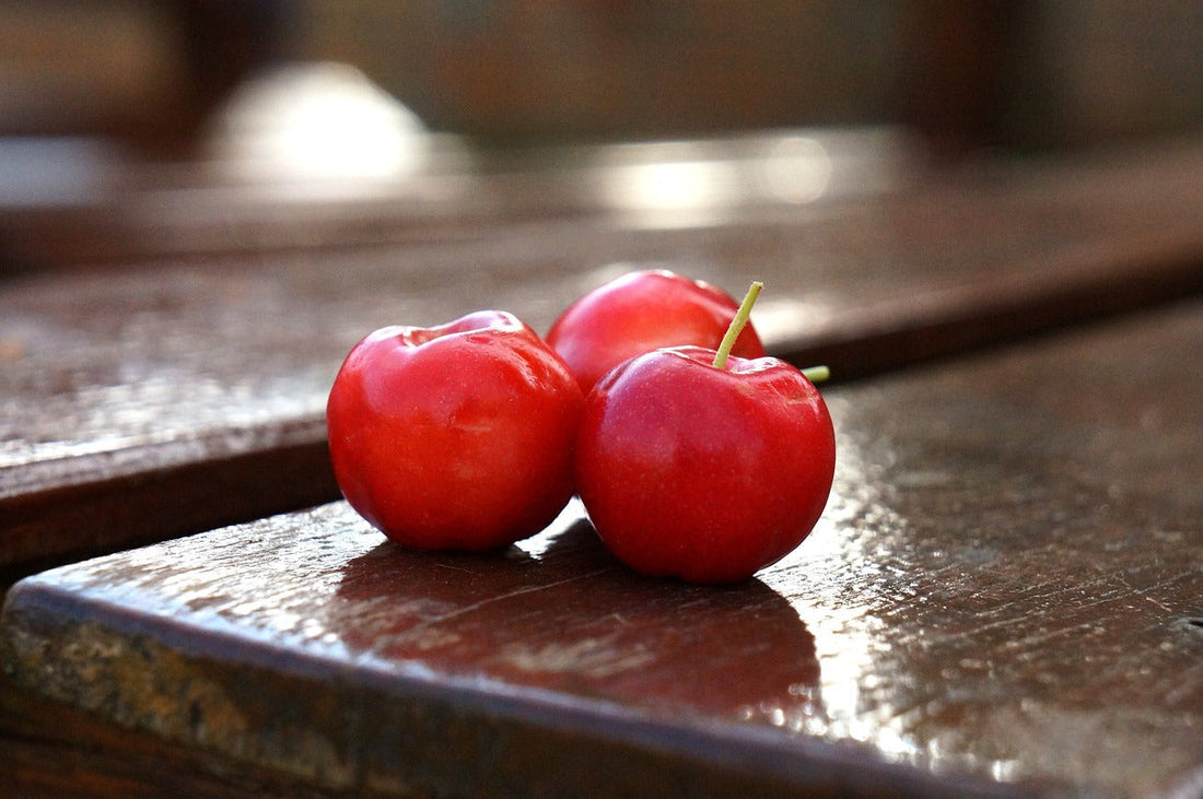 Baies d’acérola fraîches sur table en bois – fruit tropical naturellement riche en vitamine C et antioxydants